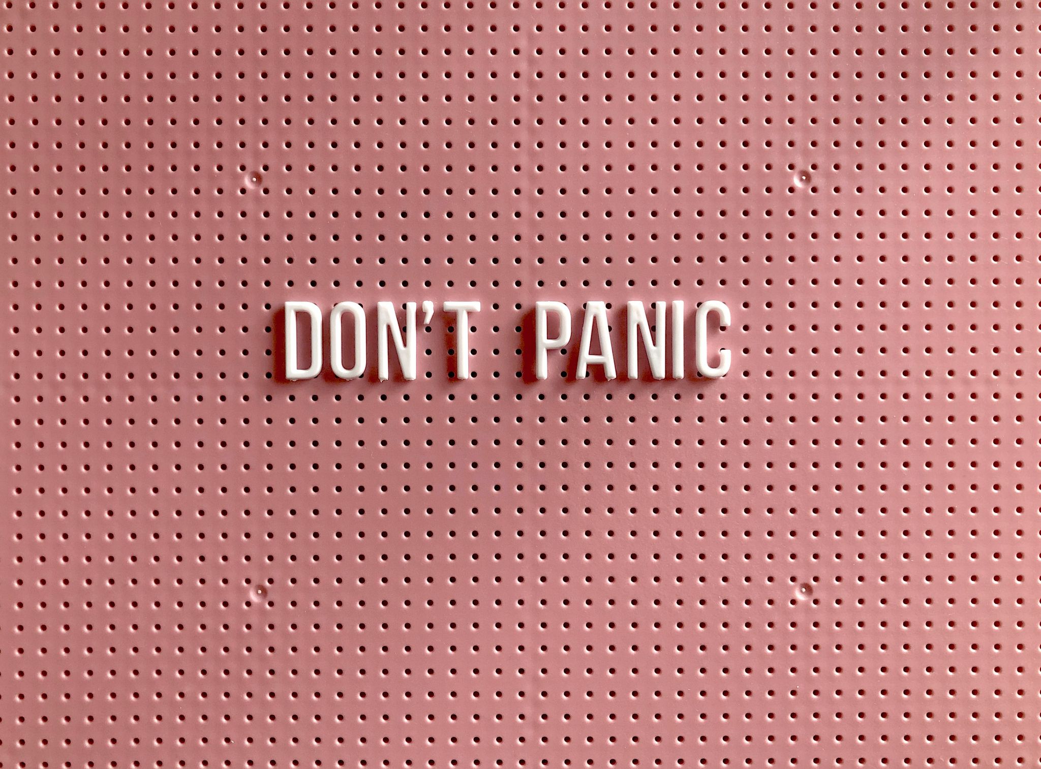 DON’T PANIC lettering on a pink background