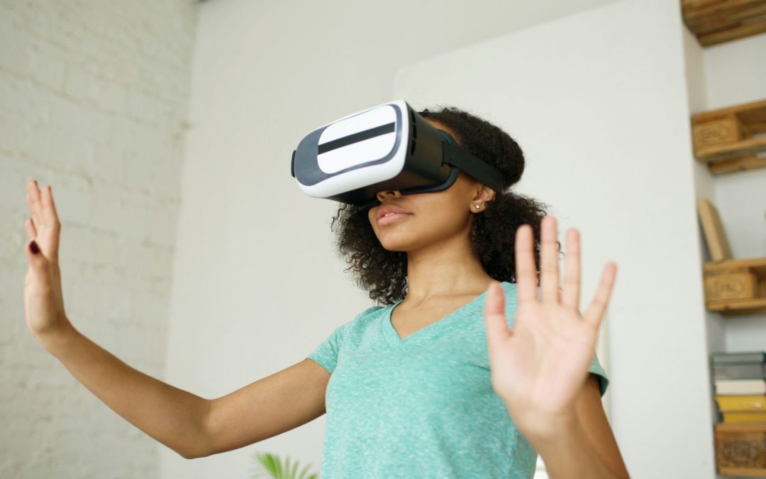 Frau mit Virtual-Reality-Brille und erhobenen Händen